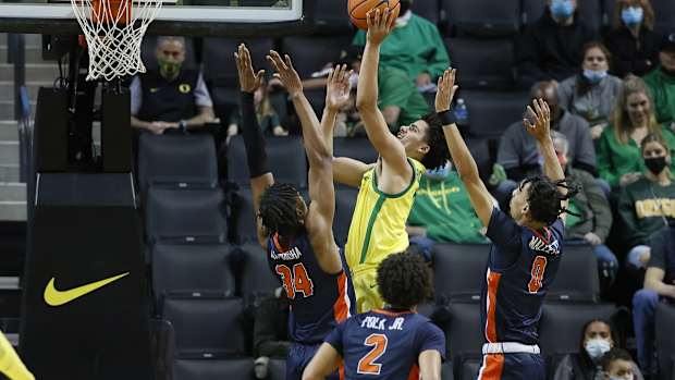 Dec 21, 2021; Eugene, Oregon, USA; Oregon Ducks guard Will Richardson (0) shoots the ball as Pepperdine Waves center Victor Ohia Obioha (34) defends during the second half at Matthew Knight Arena. Mandatory Credit: Soobum Im-USA TODAY Sports